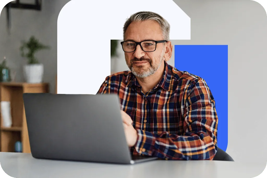 A mentor at his laptop, smiling as he listens